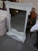 A shabby chic bedroom mirror with shelf