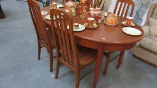 An oval teak dining table and 4 chairs