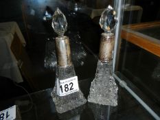 2 crystal glass bottles with silver tops,