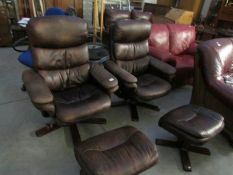 A pair of swivel reclining chairs with matching foot stools