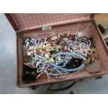A mixed lot of costume jewellery in a small leather suitcase