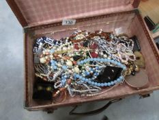 A mixed lot of costume jewellery in a small leather suitcase