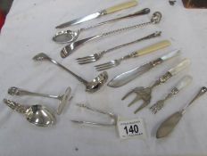 A mixed lot of silver plate cutlery including sifter spoons, sugar tongs,