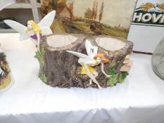 A pottery planter with fairy figurines and woodland decoration