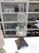 An oil lamp with cast base and glass font