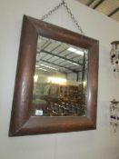 An arts and craft copper framed mirror