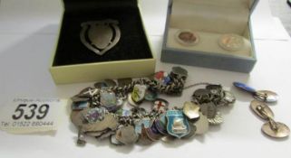 A charm bracelet with charms of various towns including silver,