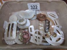 A collection of mother of pearl buttons and buckles etc