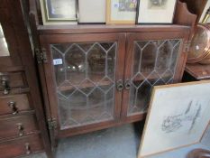 An oak lead glazed wall cabinet