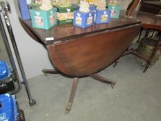 An oval mahogany drop leaf table