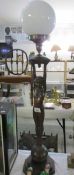 A 20th century bronzed lady table lamp with outstretched arms holding globe
