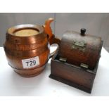 An oak and copper band tobacco jar in the shape of a barrel and an oak cigarette dispenser