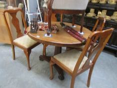 A circular mahogany dining table and 4 chairs