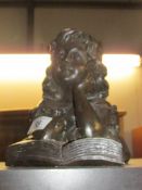 A bust of a young girl reading