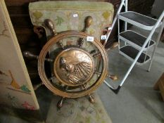 A small ship's wheel with embossed copper centre depicting fisherman