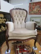 A mahogany framed gentleman's chair with beige upholstery