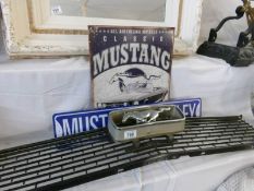 A vintage Mustang car grille with 2 reproduction Mustang car signs