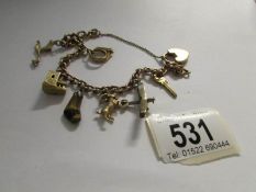 A 9ct gold charm bracelet with charms including gold