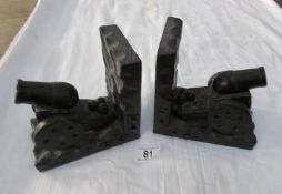 A pair of carved wood bookends in the shape of cannons