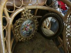 An oval mirror and a oval floral painting