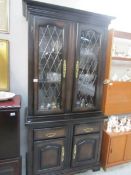 A mahogany effect display cabinet with leaded doors