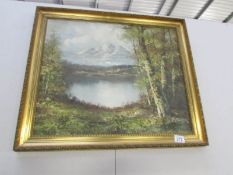 A gilt framed oil painting of lake and mountains,