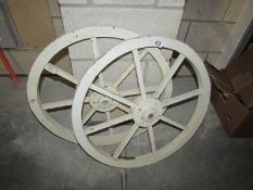 A pair of wooden hand cart wheels with metal hubs, approx.