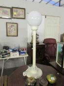 A tall modern table lamp with globe shade