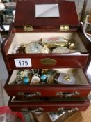 A jewellery box containing costume jewellery and compacts