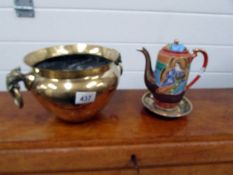 A brass pot with elephant head handles and a Japanese coffee pot on stand