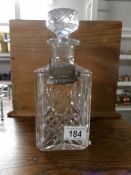 A cut glass decanter with a silver label