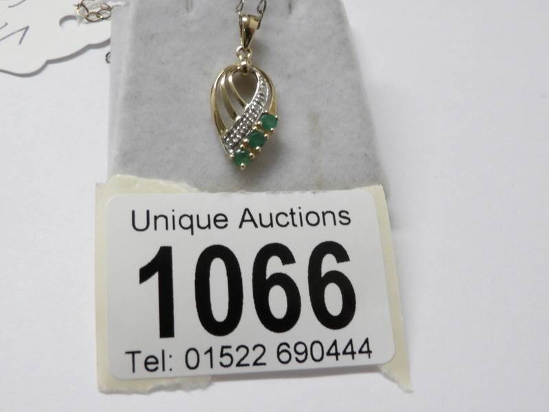 A 9ct gold diamond and emerald pendant on 9ct gold chain