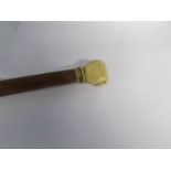 A walking cane with clenched fist finial