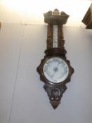 A carved oak barometer