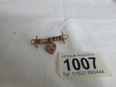 A bar brooch with gold padlock