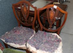 A pair of shield back chairs in need of re-upholstery