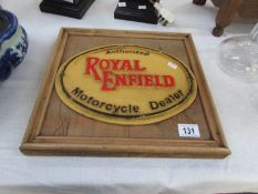 A waxed pine mounted cast iron Royal Enfield sign