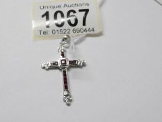 A 9ct white gold diamond and ruby set cross pendant