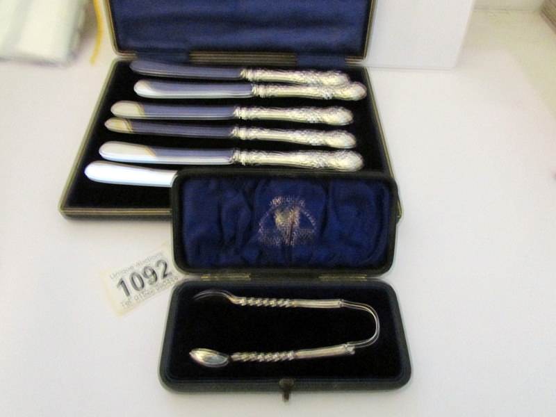 A cased set of 6 silver handled butter knives (H M Sheffield 1904-06) and a cased silver sugar nips