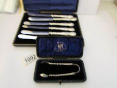 A cased set of 6 silver handled butter knives (H M Sheffield 1904-06) and a cased silver sugar nips