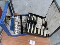 A cased set of fish knives and forks and a cased set of dessert spoons