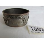 An engraved white and yellow metal bangle