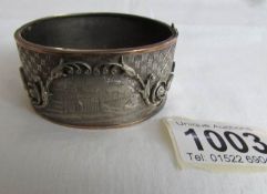 An engraved white and yellow metal bangle