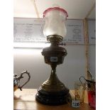 A brass oil lamp on pot base and with etched shade
