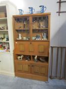 A teak cabinet with lead glazed doors