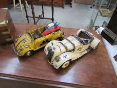 2 retro tin plate model cars being a BMW and a VW beetle