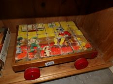 A set of 1960's wooden nursery rhyme jigsaw building blocks in pull along trolley