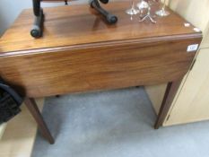 An Edwardian mahogany drop leaf table on tapered legs