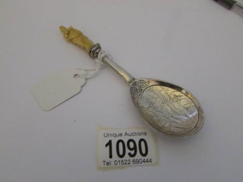 An early 20th century silver anointing spoon with ivory figure of St Paul finial