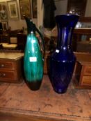 A tall blue glass vase and a pottery jug